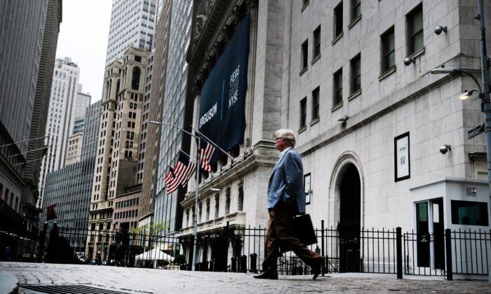 La gente camina frente a la Bolsa de Valores de Nueva York (NYSE) en la ciudad de Nueva York el 12 de mayo de 2022. Los precios de la ropa, los alimentos, la gasolina y los automóviles son solo algunos de los artículos que afectan los bolsillos de los estadounidenses a pesar del desempleo históricamente bajo. (Spencer Platt/Getty Images)