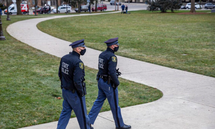 La policía patrulla afuera del Capitolio del Estado de Michigan mientras manifestantes pro-Trump protestan cerca en Lansing, Michigan, el 14 de diciembre de 2020. (Elaine Cromie/Getty Images)
