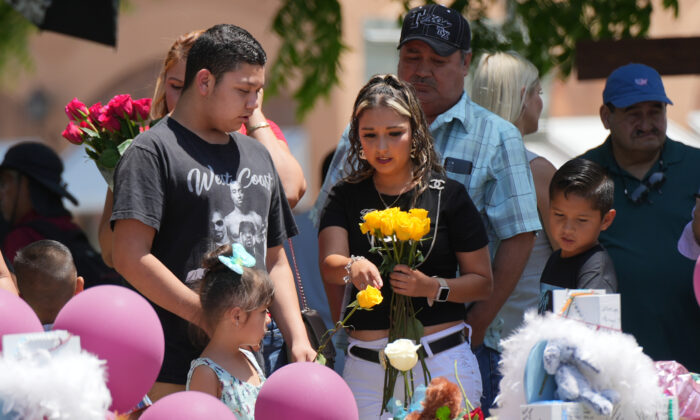 La gente visita un memorial improvisado para las 21 víctimas del tiroteo masivo en una escuela primaria en la plaza del poblado de Uvalde, Texas, el 29 de mayo de 2022. (Charlotte Cuthbertson/The Epoch Times)