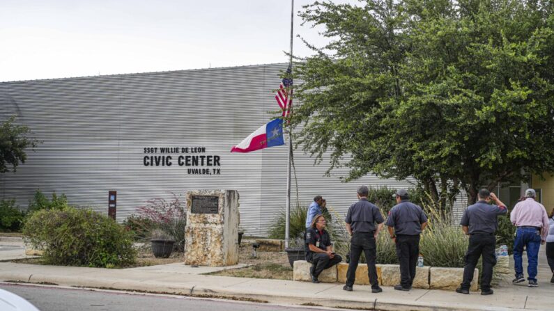 Un hombre baja las banderas de Estados Unidos y Texas a media asta fuera del Centro Cívico de Uvalde después de un tiroteo masivo en una escuela primaria, en Uvalde, Texas, el 24 de mayo de 2022. (Charlotte Cuthbertson/The Epoch Times)
