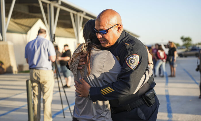 El jefe de policía del distrito escolar de Uvalde, Pete Arredondo, abraza a una estudiante de escuela en una noche de oración comunitaria celebrada un día después del tiroteo masivo en la escuela primaria Robb, que dejó un saldo de 19 niños y dos maestras fallecidas, en Uvalde, Texas, el 25 de mayo de 2022. (Charlotte Cuthbertson/The Epoch Times)