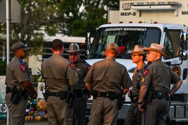 Oficiales de policía hablan cerca de un monumento improvisado para las víctimas del tiroteo, afuera de la Escuela Primaria Robb, en Uvalde, Texas, el 27 de mayo de 2022. (Chandan Khanna/AFP vía Getty Images)
