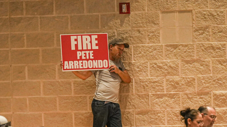 Un hombre sostiene un cartel de "Despidan a Pete Arredondo" en la reunión del Distrito Escolar Independiente Consolidado de Uvalde, Texas, el 20 de junio de 2022. (Charlotte Cuthbertson/The Epoch Times)

