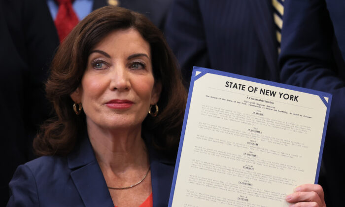 La gobernadora de Nueva York, Kathy Hochul, sostiene la legislación promulgada durante una ceremonia en las instalaciones de la YMCA del Bronx en la ciudad de Nueva York el 6 de junio de 2022. (Michael M. Santiago/Getty Images)