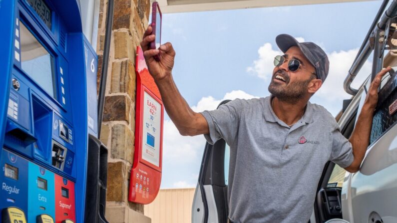 Guy Benhamou envía una foto de los precios de la gasolina a sus amigos mientras carga gasolina en una gasolinera de Exxon Mobil en Houston, Texas, el 9 de junio de 2022. (Brandon Bell/Getty Images)