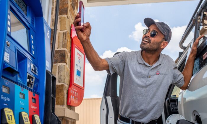 Guy Benhamou envía una foto de los precios de la gasolina a sus amigos mientras carga gasolina en una gasolinera Exxon Mobil en Houston, el 9 de junio de 2022. (Brandon Bell/Getty Images)