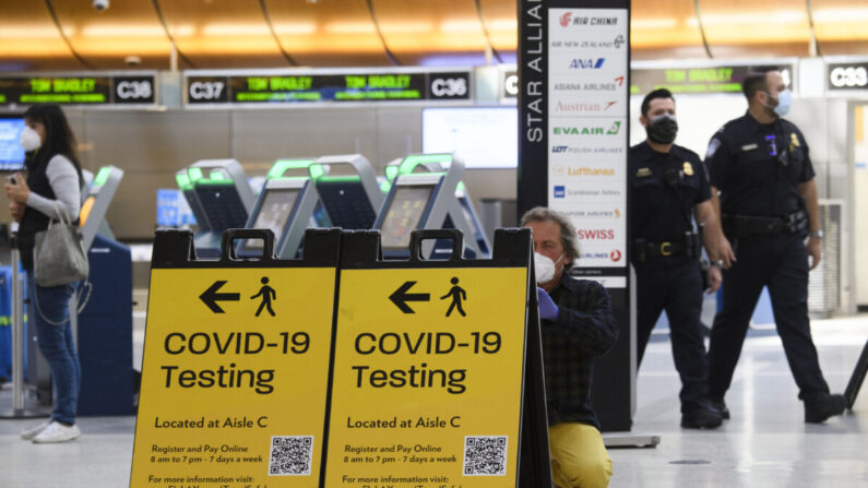 Un viajero toma una foto de un cartel de prueba de COVID-19 en la Terminal Internacional Tom Bradley, en Los Ángeles, California, el 4 de febrero de 2021. (Patrick T. Fallon/AFP vía Getty Images)
