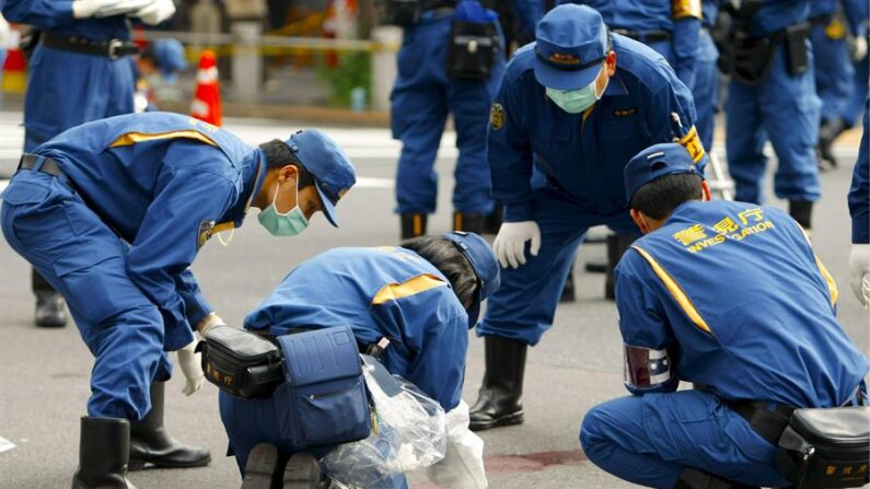 Un equipo de investigadores de la policía revisa un charco de sangre en el barrio de Akihabara, en el centro de Tokio (Japón) el 8 de junio de 2008. EFE/Kai Kurokawa