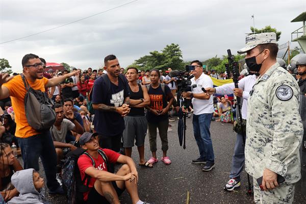 Personal de la Guardia Nacional (GN) impiden el paso a migrantes al Centro de Atención al Tránsito Fronterizo (CAIF), hoy en el municipio de Huixtla, en Chiapas (México). EFE/Juan Manuel Blanco
