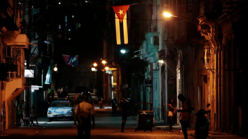Varias personas caminan por una calle iluminada por el alumbrado público en La Habana, Cuba, en una fotografía de archivo. EFE/Ernesto Mastrascusa