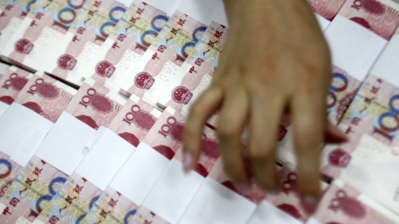 Un trabajador chino cuenta una pila de billetes de 100 yuanes en un banco de Kaifeng, en la provincia oriental china de Anhui, el 22 de junio de 2010. (STR/AFP a través de Getty Images)