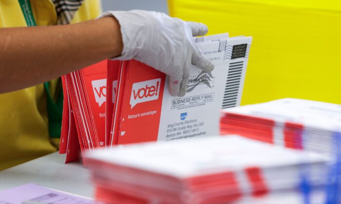 Un trabajador electoral abre sobres que contienen boletas de voto por correo para las primarias del estado de Washington del 4 de agosto en las elecciones del condado de King en Renton, Washington, el 3 de agosto de 2020. (Jason Redmond/AFP vía Getty Images)