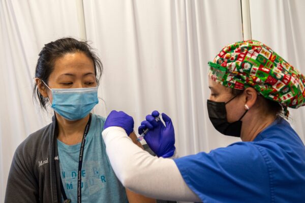 La enfermera y veterana del ejército, Renee Langone, administra una vacuna anti-COVID de Moderna a la Dr. Pei-Chun McGregor, de la Fuerza Aérea (reservista en servicio activo), en el Centro Médico de Veteranos de West Roxbury, en Boston, Massachusetts, el 23 de diciembre de 2020. (Joseph Prezioso/AFP vía Getty Images)