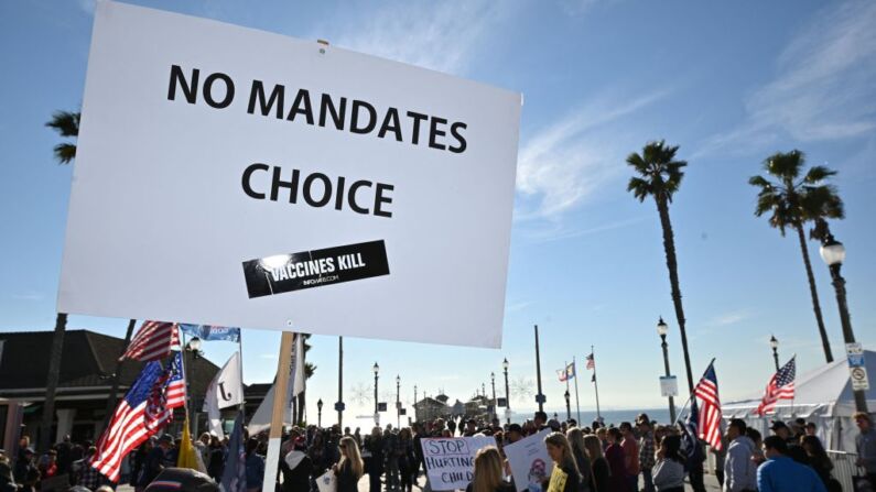 Las personas se manifiestan en contra de los mandatos de la vacuna Covid-19 para los estudiantes en Huntington Beach, California, el 3 de enero de 2022. (Foto de ROBYN BECK/AFP a través de Getty Images)