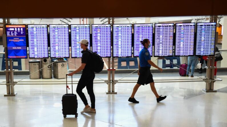 Un agente de la Administración de Seguridad en el Transporte (TSA) pasa junto a un pasajero en el Aeropuerto Internacional de Denver en Colorado el 19 de abril de 2022. (Patrick T. Fallon/AFP vía Getty Images)
