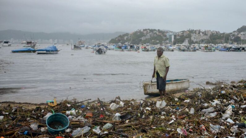 Hombre recoge basura en la playa de la Bahía de Santa Lucía en Acapulco, estado de Guerrero, México, el 16 de junio de 2022, tras el paso del huracán Blas. (Francisco Robles/AFP vía Getty Images)