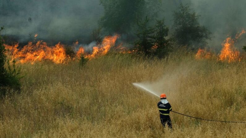 En una fotografía de archivo, un bombero rocía agua después de un incendio en Via delli Estensi en Roma (Italia) el 22 de junio de 2022. (Andreas Solaro/AFP vía Getty Images)