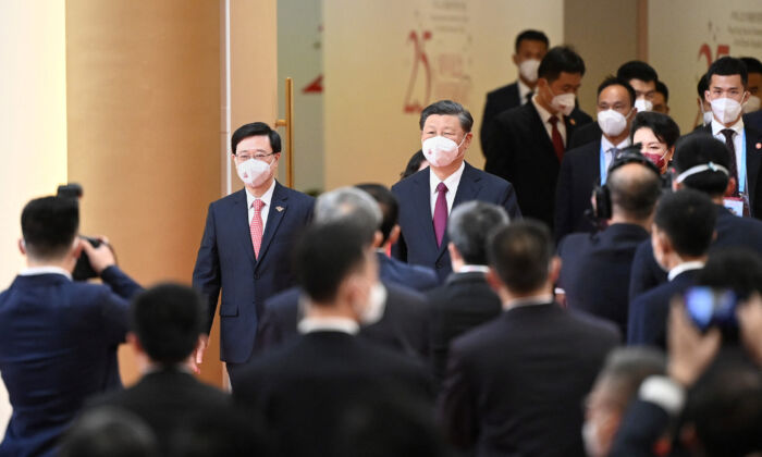 El líder chino Xi Jinping (C) llega con el jefe ejecutivo entrante de Hong Kong, John Lee (iz), en Hong Kong el 1 de julio de 2022, (Selim Chtayti/POOL/AFP vía Getty Images)
