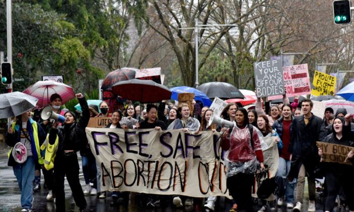 Los manifestantes llevan una pancarta por las calles durante una manifestación en apoyo del derecho al aborto en el distrito central de negocios de Sydney, Australia, el 2 de julio de 2022. (MUHAMMAD FAROOQ/AFP a través de Getty Images)