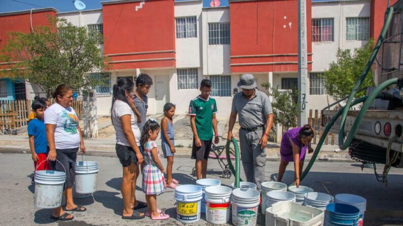 Residentes hacen cola para recoger agua potable de un camión cisterna en el municipio de García, al noroeste de la zona metropolitana de Monterrey, Estado de Nuevo León, México, el 5 de julio de 2022. (Julio Cesar Aguilar/AFP vía Getty Images)