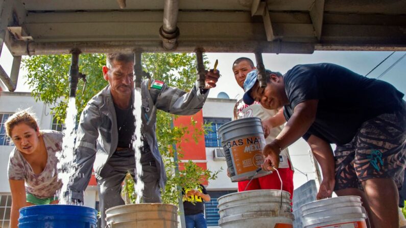 Residentes recogen agua potable de un camión cisterna en el municipio de García, al noroeste del área metropolitana de Monterrey, Estado de Nuevo León, México, el 5 de julio de 2022. (Julio Cesar Aguilar/AFP vía Getty Images)