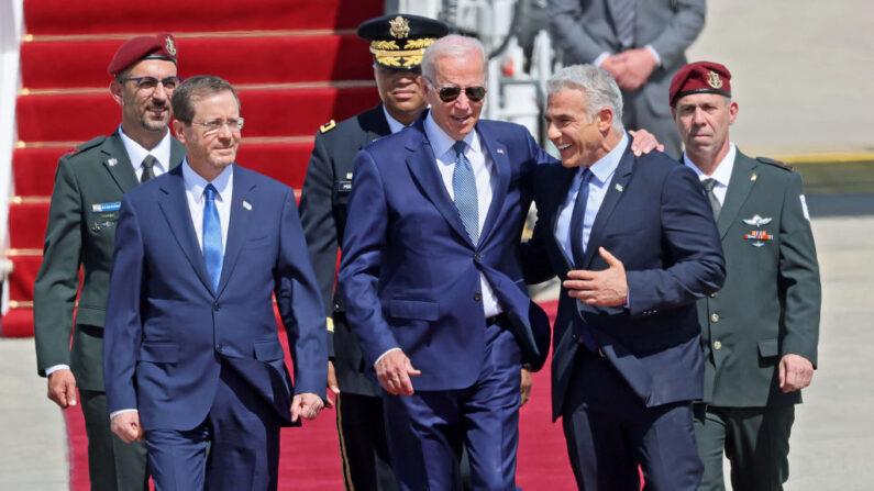El presidente estadounidense Joe Biden (c) es recibido por el presidente israelí Isaac Herzog (i) y el primer ministro interino Yair Lapid a su llegada al aeropuerto Ben Gurion en Lod, cerca de Tel Aviv, el 13 de julio de 2022. (Jack Guez/AFP vía Getty Images)