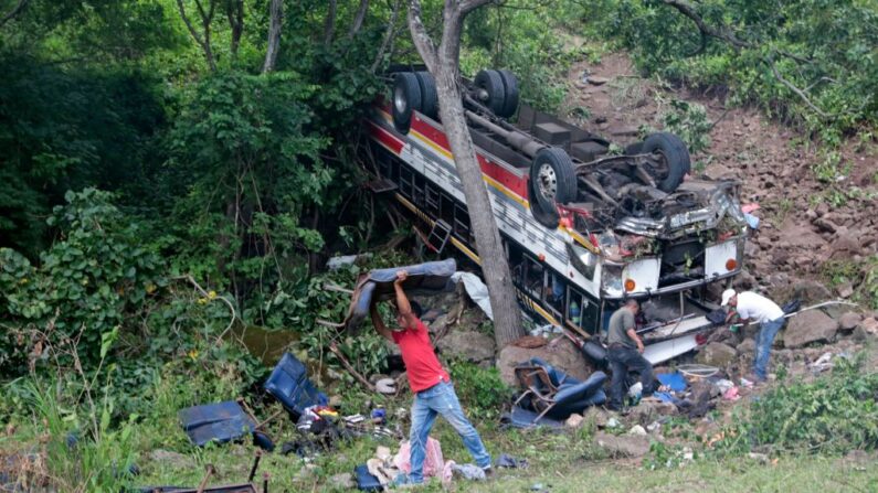 Personas retiran los asientos de un autobús accidentado en la carretera Panamericana en Condega, Nicaragua, el 28 de julio de 2022. (Oswaldo Rivas/AFP vía Getty Images)

