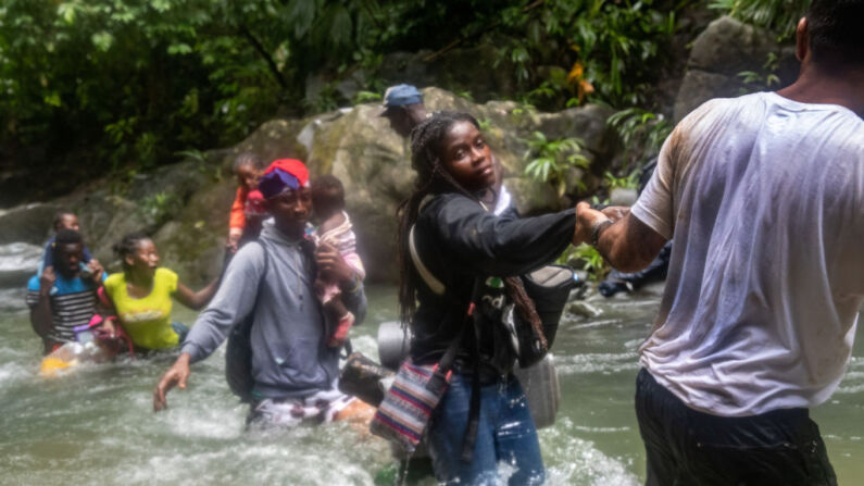Familias de inmigrantes, cruzan uno de los muchos ríos en el primer día de su viaje el 18 de octubre de 2021 a través del Tapón del Darién, en Colombia. (Foto de John Moore/Getty Images)
