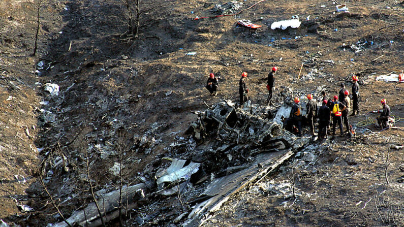 En una fotografía de archivo, bomberos y personal de rescate buscan entre los restos de un avión estrellado en una ladera el 15 de agosto de 2005 cerca de Grammatiko, Grecia. (Milos Bicanski/Getty Images)