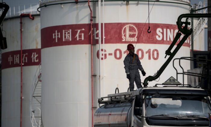 Un hombre trabaja en una estación de servicio de Sinopec, China Petroleum and Chemical Corporation, en Shanghái el 22 de marzo de 2018. (Johannes Eisele/AFP vía Getty Images)