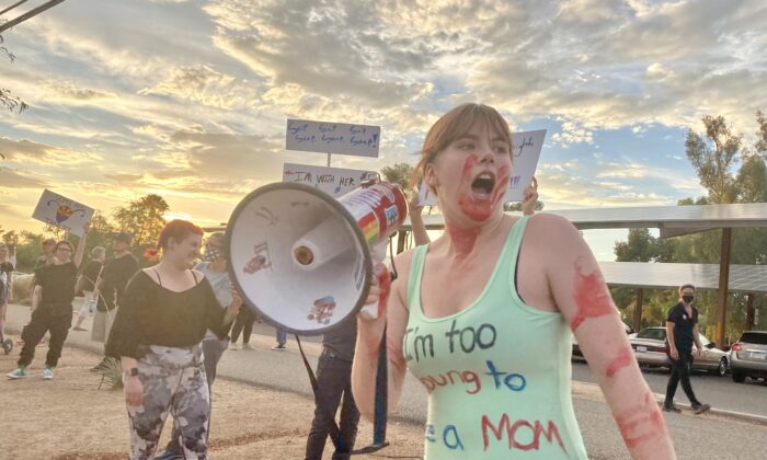Una manifestante, no identificada, cubierta con sangre falsa grita por un megáfono en una marcha proaborto. La marcha fue impulsada por el Partido Demócrata del Condado de Pima, en Tuscon, Arizona, el 4 de julio del 2022. (Allan Stein/The Epoch Times)
