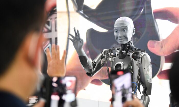Visitantes toman fotografías e interactúan con el robot humanoide, Ameca, que tiene inteligencia artificial, durante el Consumer Electronics Show (CES), en Las Vegas, Nevada, el 5 de enero de 2022. (Patrick T. Fallon/AFP a través de Getty Images)
