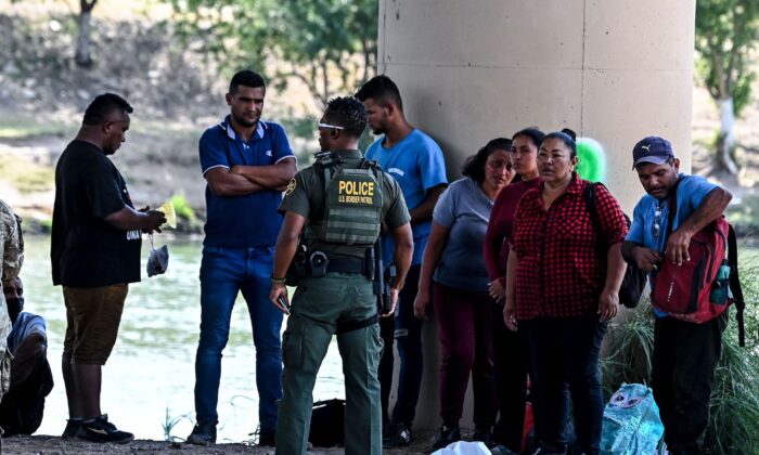Los inmigrantes ilegales son detenidos por la Patrulla Fronteriza de EE. UU. y las tropas de la Guardia Nacional en Eagle Pass, Texas, cerca de la frontera con México, el 30 de junio de 2022. (Chandan Khanna/AFP a través de Getty Images)