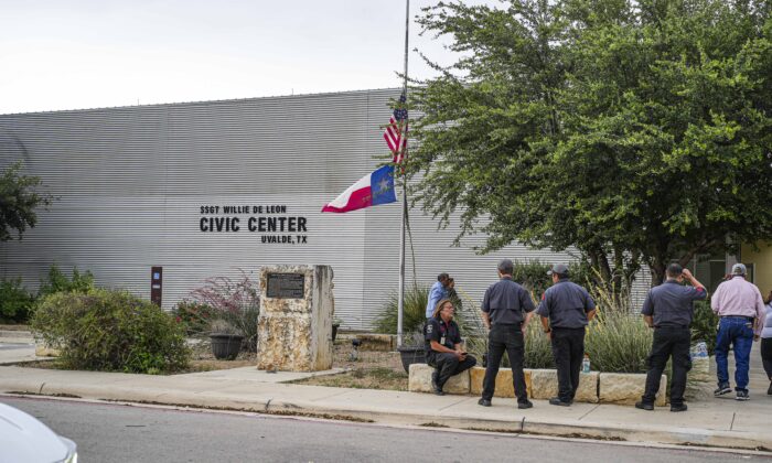 Un hombre baja las banderas de EE. UU. y Texas a media asta afuera del Centro Cívico de Uvalde luego de un tiroteo masivo en una escuela primaria, en Uvalde, Texas, el 24 de mayo de 2022. (Charlotte Cuthbertson/The Epoch Times)