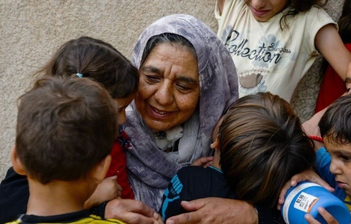 Anciana rodeada de niños. Imagen ilustrativa. (ZAID AL-OBEIDI/AFP vía Getty Images)