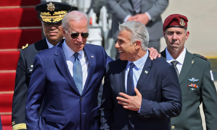 El presidente Joe Biden (izq.) es recibido por el primer ministro interino israelí Yair Lapid tras llegar al aeropuerto israelí Ben Gurion en Lod, cerca de Tel Aviv, el 13 de julio de 2022. (Jack Guez/AFP vía Getty Images)