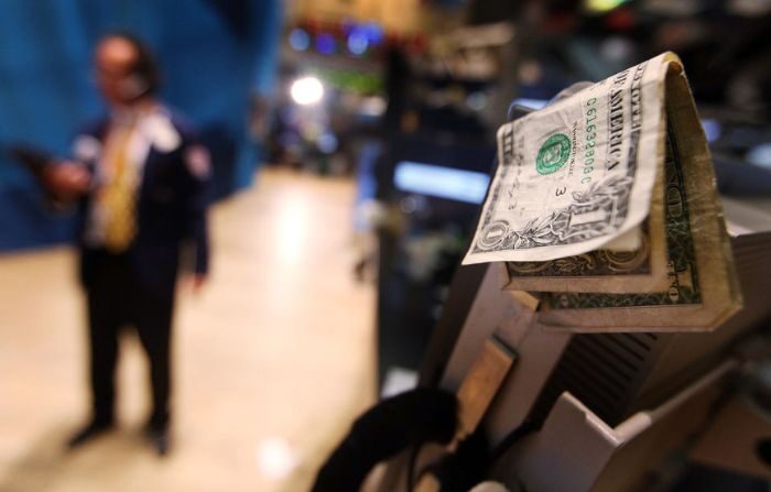 Billetes de dólar se ven unidos a una computadora en el piso de la Bolsa de Valores de Nueva York antes de la campana de cierre el 19 de julio de 2011 en la ciudad de Nueva York. (Mario Tama/Getty Images)
