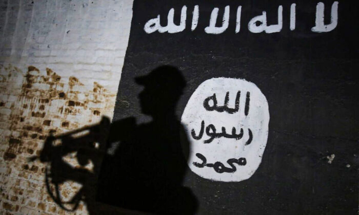 Un mural lleva el logo del grupo terrorista ISIS. (Ahmad Al-Rubaye/AFP a través de Getty Images)
