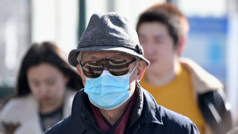 Un hombre usa una mascarilla quirúrgica en Flushing, un vecindario en el distrito de Queens en la ciudad de Nueva York, el 3 de febrero de 2020. (Johannes Eisele/AFP a través de Getty Images)