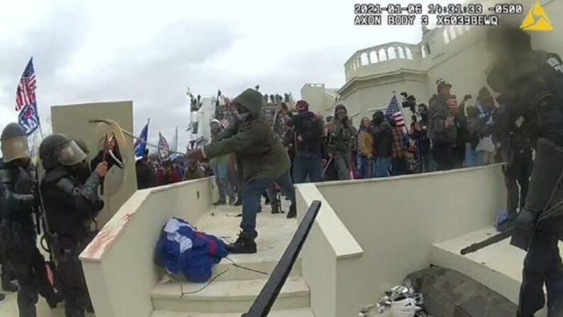 En esta imagen de video, Mark Ponder (C) golpea a un oficial de la Policía del Capitolio de Estados Unidos el 6 de enero de 2021. (Departamento de Justicia vía The Epoch Times)
