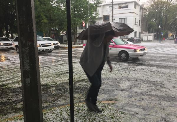 Fotografía de archivo de una persona que camina bajo la lluvia por una avenida en Ciudad de México (México). EFE/Jorge Núñez
