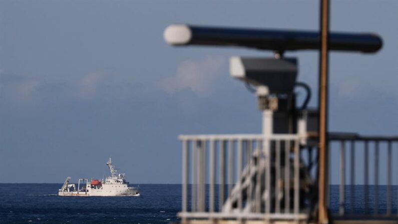 Una embarcación maniobra frente a una torre de radar mientras se aleja del lugar donde se cree que los militares chinos realizan un simulacro de fuego real, se ve desde la costa de la ciudad de Nuevo Taipéi, Taiwán. (EFE/EPA/Ritchie B. Tongo) 