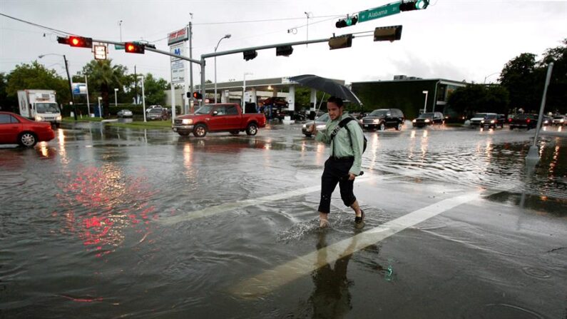 Fotografía de archivo de un joven que cruza cuidadosamente una calle inundada en Houston, en el estado de Texas, Estados Unidos. EFE/Aaron M. Sprecher
