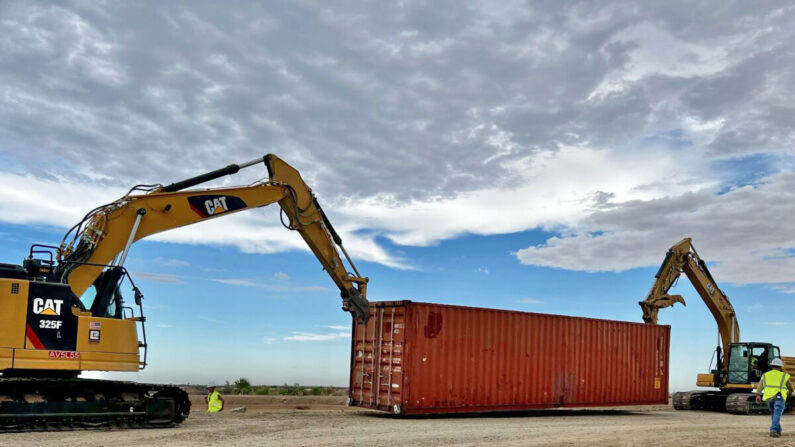 Contratistas comienzan a apilar contenedores de transporte en los huecos de la valla fronteriza cerca de Yuma, Arizona, el 12 de agosto de 2022. (Cortesía de la oficina del gobernador de Arizona)
