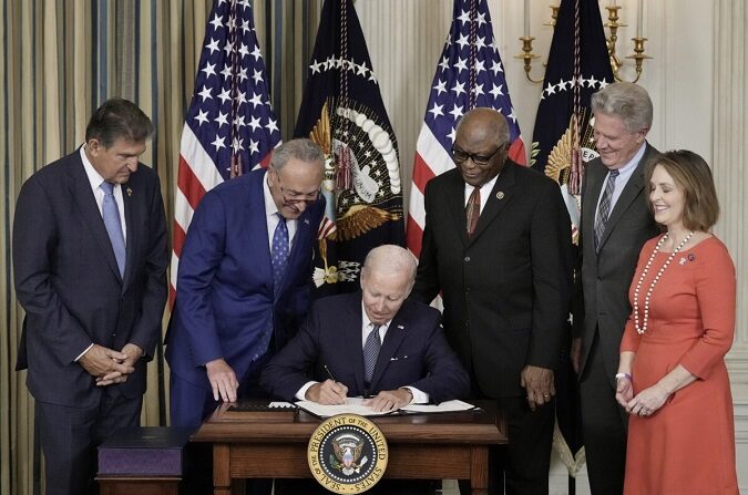 El presidente Joe Biden firma la Ley de Reducción de la Inflación ante la mirada de los legisladores demócratas en la Casa Blanca, en Washington, el 16 de agosto de 2022. (Drew Angerer/Getty Images)
