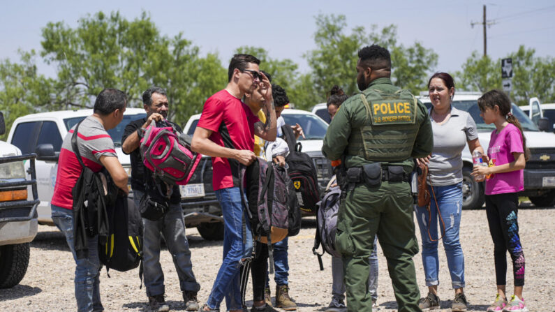 Un agente de la Patrulla Fronteriza organiza un grupo de inmigrantes ilegales cerca de Eagle Pass, Texas, el 20 de mayo de 2022. (Charlotte Cuthbertson/The Epoch Times)
