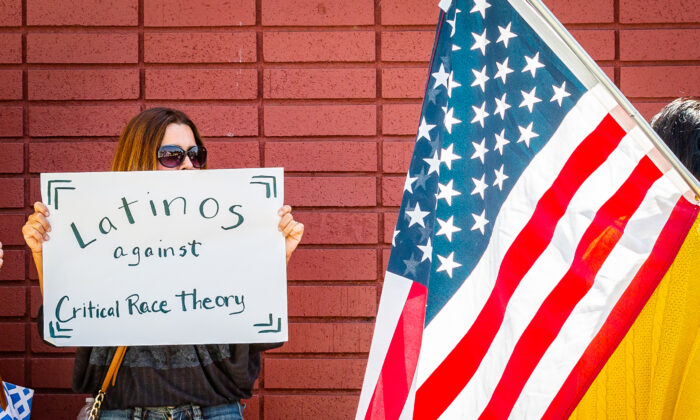 Una mujer sostiene un cartel que desalienta la teoría crítica de la raza en Los Alamitos, California, el 11 de mayo de 2021. (John Fredricks/The Epoch Times)