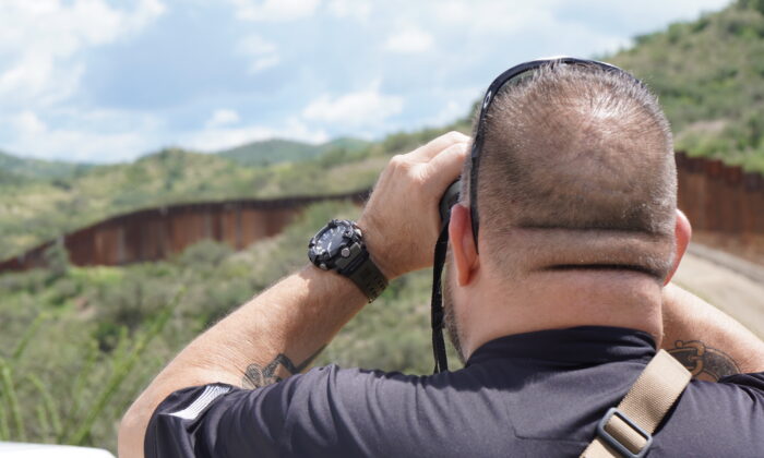 Sam, propietario de una empresa de seguridad de alta tecnología en Arizona, examina la valla del muro de la frontera sur en busca de actividad de contrabando ilegal el 25 de agosto de 2022. (Allan Stein/The Epoch Times)