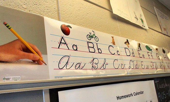 Un cartel que muestra a los alumnos de tercer grado cómo escribir en letra impresa y cursiva recorre la parte superior de una pizarra de la escuela primaria Triadelphia Ridge en Ellicott City, Maryland, el 15 de octubre de 2013. (Robert MacPherson/AFP/Getty Images)