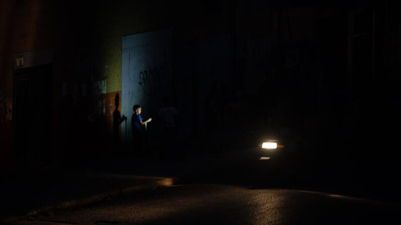 El faro de una moto ilumina a un niño mientras camina por una calle, durante un apagón en Caracas (Venezuela), en una fotografía de archivo. EFE/ Rayner Pena R